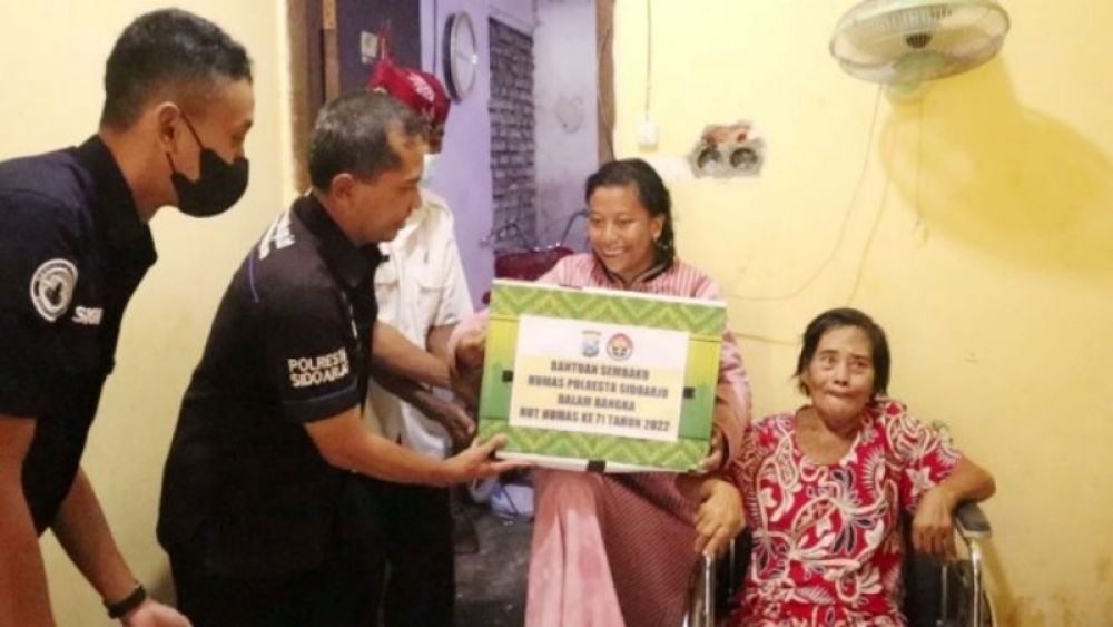 Ps. Si Humas Polresta Sidoarjo Iptu Tri Novi Handono memberikan bantuan paket sembako kepada Tutik Sukani, (lansia) warga Taman Sepanjang. (Ist) 