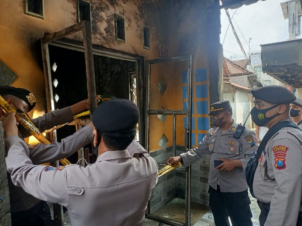 Petugas Polsek Kediri Kota sedang melakukan olah TKP di rumah yang terbakar di Kampung Dalem Kota Kediri. (Ist) 