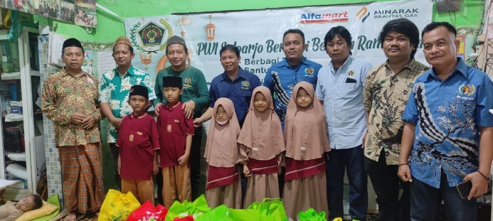 Pengurus Yayasan Al Kahfi Ustadz, Wahyudi (kiri) bergoto bersama pengurus dan anggota PWI Sidoarjo usai serahkan santunan. (Ist) 
