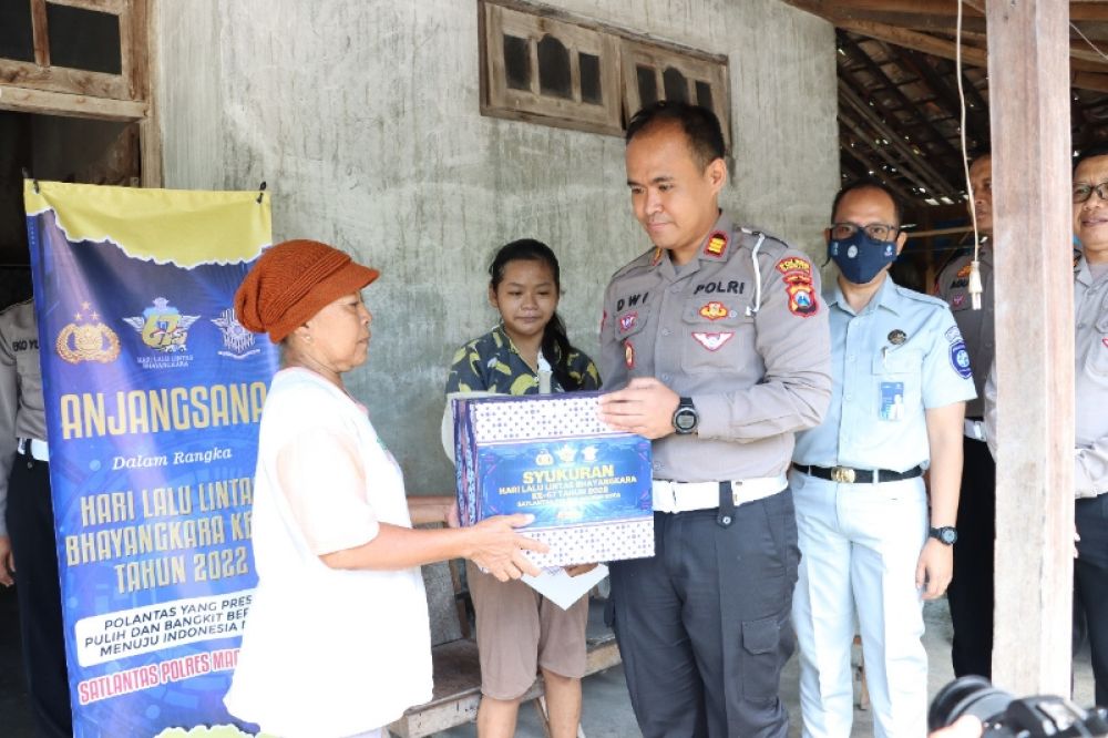 Sumiatun (55), warga Rusunawa Kecamatan Manguharjo Kota Madiun saat menerima bantuan paket sembako dan taliasih dari Kasatlantad Polres Madiun Kota , AKP Dwi Jatmiko. (Ist) 