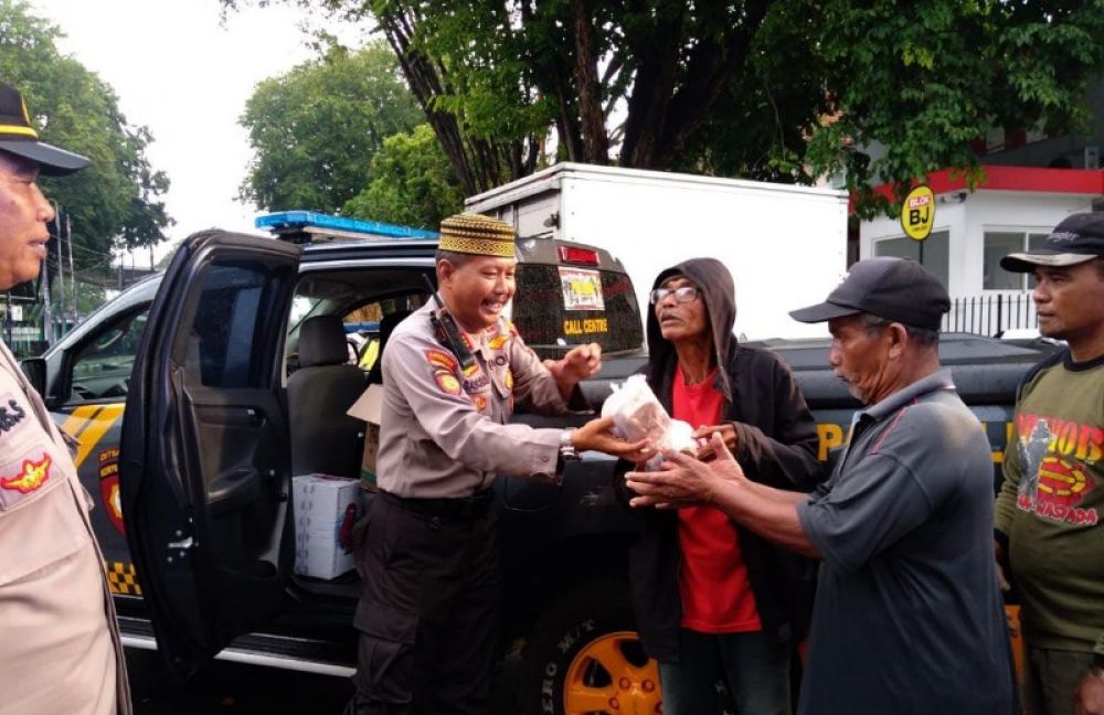 Kasat Samapta Polresta Banyuwangi AKP Basori Alwi memberikan hidangan ringan untuk berbuka puasa pada pekerja kasar di taman Sritanjung, Selasa (28/03/2023). (Ist) 
