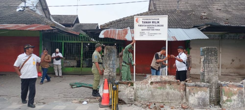 Pedagang pasar lama di Bojonegoro sebagian masih ada yang tetap bertahan dan berjualan di tempat tersebut meskipun pihak pemkab meminta untuk pindah. Tampak petugas memasang plang legalitas kepemilikan lahan (ist) 