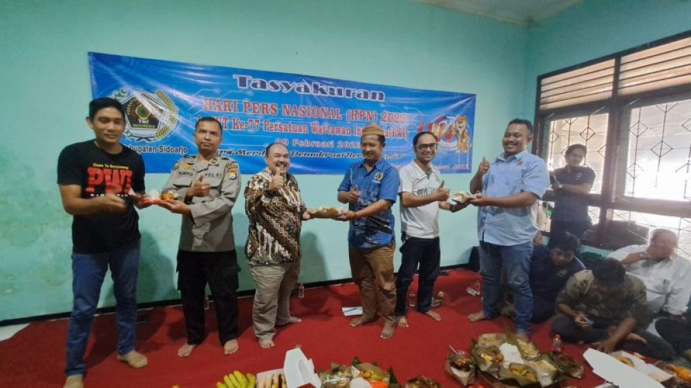 Ketua PWI Sidoarjo, Mustsin berikan potongan tumpeng kepada Kadiskominfo Sidoarjo dalam acara Tasyakuran peringati HPN 2023 di kantor Balai Wartawan. (Ist) 