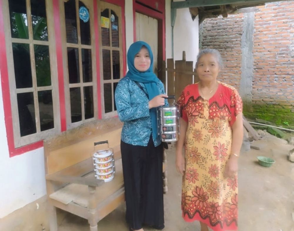 Salah seorang keluarga penerima manfaat (KPM) saat menerima ransuman (pengiriman makan gratis) dari ketua PKK Kecamatan. (Ist) 