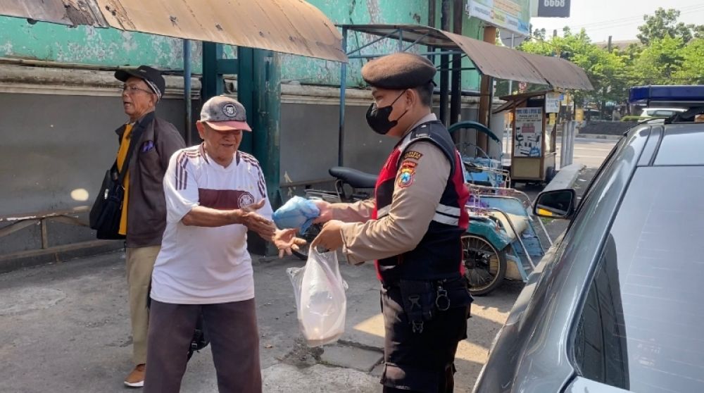 Kasat Samapta Polresta, Sidoarjo Kompol Warih Hutomo memberikan nadi kotak kepada warga. (Ist) 