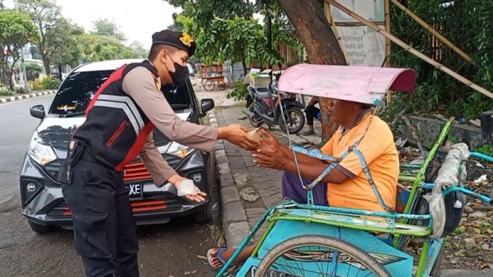 Anggota Samapta Polresta Sidoarjo peduli sesama dengan berbagi nasi bungkus. (Ist) 
