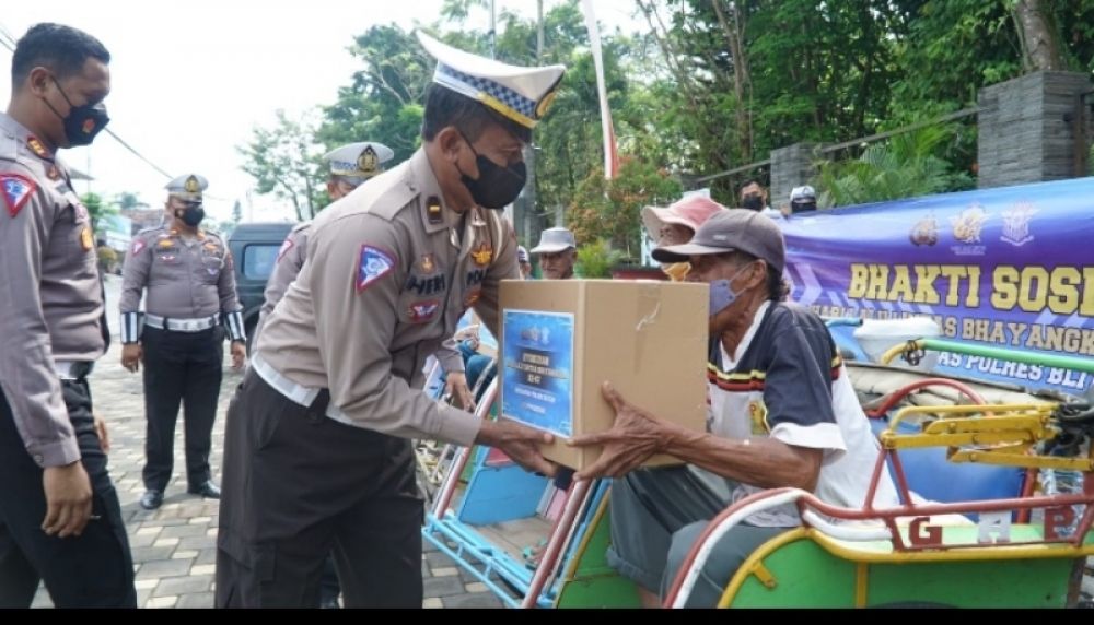 Kasat Lantas Polres Blitar AKP Kadek Aditya Yasa Putra, S.I.K, MH, MSi, saat membagikan bingkisan paket sembako kepada abang becak. (Ist) 