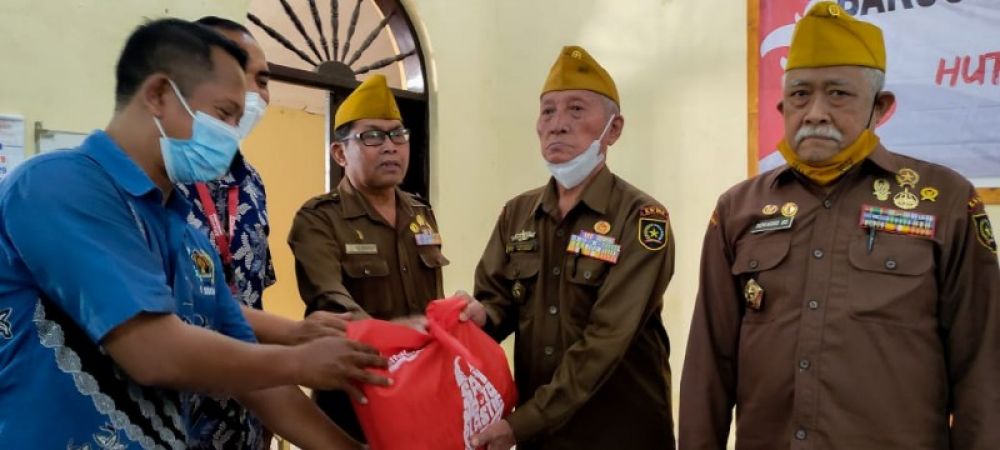 Ketua PWI Sidoarjo Mustain menyerahkan bingkisan dalam acara baksos untuk Veteran. (Ist) 