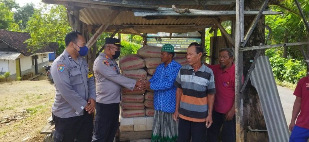 Kapolsek Wonotirto, AKP Supriadi, menyerahkan bantuan Semen kepad takmir masjid Baitussyafa'ah, Ustadz Sugito. Foto Bawah: Kapolsek Supriadi menurunkan Semen dari mobil box. (Ist) 
