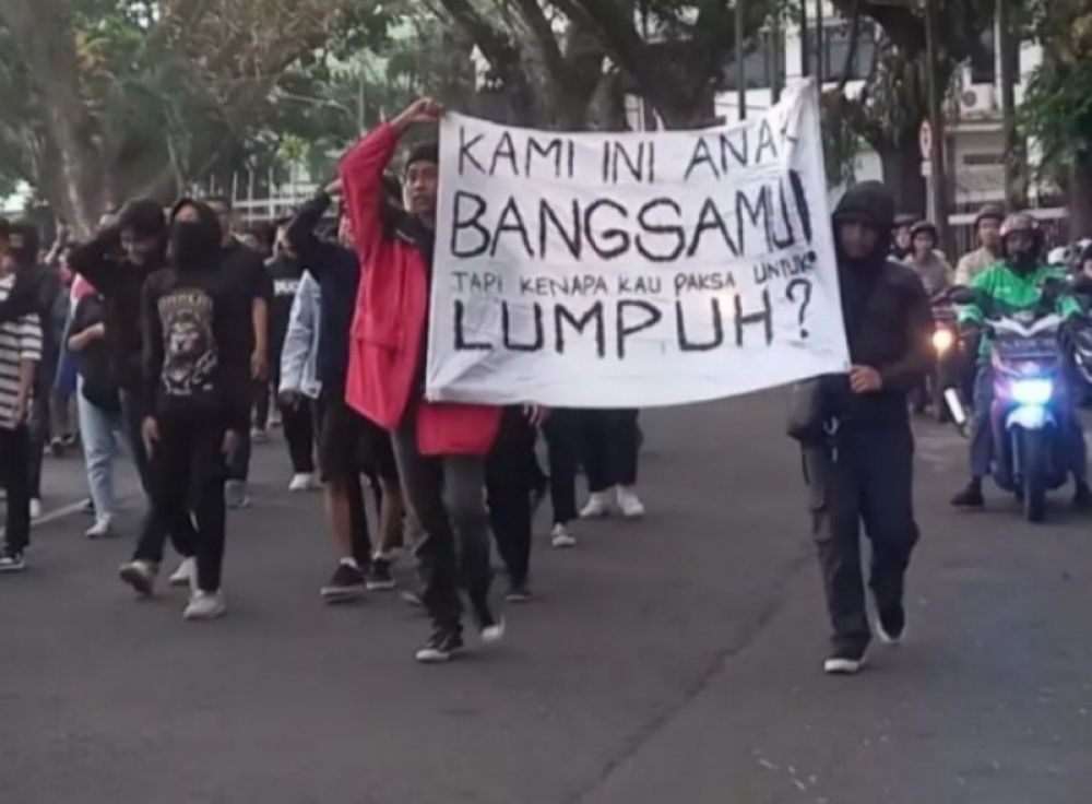 Ratusan suporter Arema menggelar aksi demo sambil membentangkan spanduk di depan Kantor Balai Kota Malang. (Ist) 