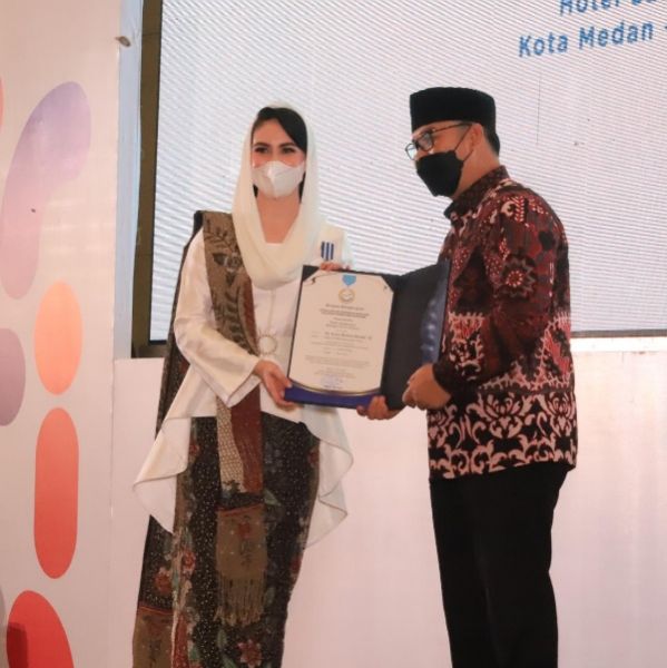 Ketua BKKBN RI Hasto Wardoyo menyerahkan penghargaan MKK kepada Ketua TP PKK Jatim Arumi Bachsin Emil Dardak di Hotel Santika Dyandra Convention Center Medan. (Ist) 