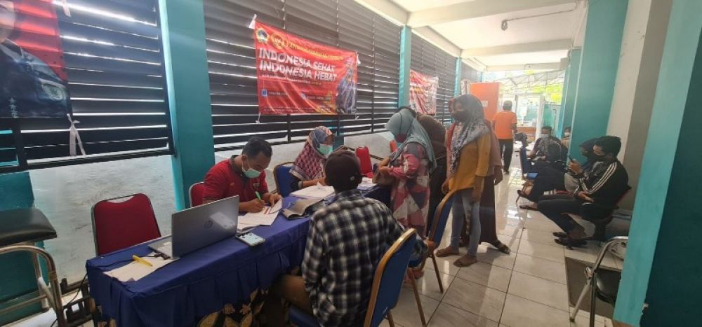 Petugas Puskesmas Cerme saat memeriksa tensi darah sebelum di suntik vaksin warga Cerme sedang antri menunggu giliran. (Ist) 