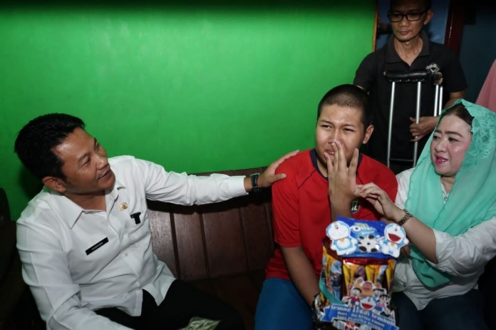 Wabup Subandi saat menjenguk dan berikan bantuan anak berkebutuhan khusus di Tulangan. (Ist) 