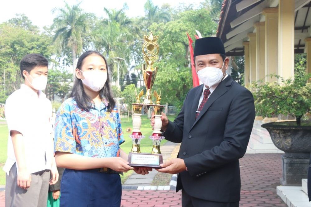 Wabup Subandi menyerahkan penghargaan kepada siswi berprestasi dalam upacara Hardiknas di Alun-alun Sidoarjo. (Ist) 