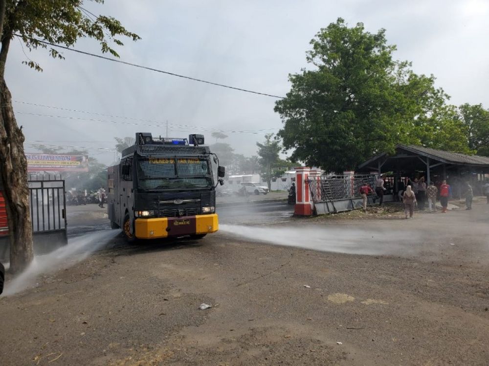 Watercanon Polres Blitar sedang menyemprotkan disinfektan ke pasar Dimoro. (Ist) 
